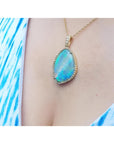 12.16 ct Australian opal pendant with bluish-green play-of-color, handcrafted in 18K yellow gold.
