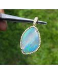 12.16 ct. Australian opal pendant with bluish-green play-of-color, handcrafted in 18K yellow gold.