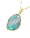 Opal pendant necklace with gold chain on a left-side profile view.