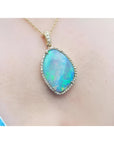 12.16 ct Australian opal pendant with bluish-green play-of-color, set in 18K yellow gold with diamonds.