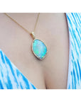 12.16 ct Australian opal pendant with bluish-green play-of-color, set in 18K yellow gold with diamonds.