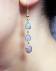 Handcrafted 14k yellow gold dangle earrings with three pear and oval-cut Australian opals.