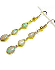 Handcrafted 14k yellow gold dangle earrings with three pear and oval-shaped Australian opals.