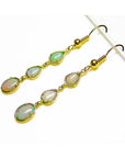 Handcrafted 14k yellow gold dangle earrings with three pear and oval-shaped Australian opals.