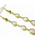Gold earrings with opal stones on a white background
