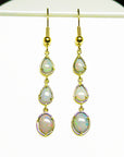 Gold earrings with natural Australian opal stones in yellow gold on a white background.