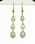 Gold earrings with natural Australian opal stones in yellow gold on a white background.