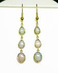Pear and oval Australian opal dangle earrings in 14k yellow gold.