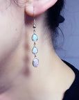 Handcrafted 14k yellow gold earrings with three dangling Australian opals: two pear-shaped, one oval.