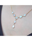 Handcrafted 14K yellow gold necklace with seven solid Australian opals, worn on a person.