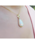 Pear-shaped Australian opal pendant necklace with red-orange flashes in 14k yellow gold.