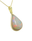 A natural Australian opal pendant pear shaped on a gold chain displaying its topside right profile.