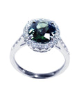 Oval bluish-green Australian sapphire ring with diamond halo, set in 18K white gold.