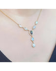 14k yellow gold necklace with a black opal center, diamond halo, and teardrop opals.