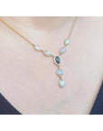 14k yellow gold necklace with a black opal center, diamond halo, and teardrop opals.