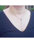 14k yellow gold necklace with black Australian opal and diamond halo, featuring pear-shaped opals.
