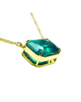 Emerald-cut Colombian emerald solitaire necklace in 18K yellow gold.