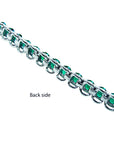 The backside profile view of a white gold emerald tennis bracelet.