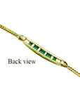 This backside view of a gold bracelet with emeralds on an underside position.