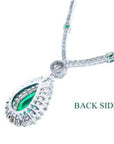 Back view of 18K white gold necklace with pear-cut emerald pendant and diamond halo.