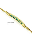 The backside view profile of a yellow gold emerald bracelet.
