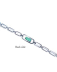 Back side of a 14K white gold paper clip bracelet with a medium deep bluish-green emerald.