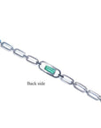 Back side of a 14K white gold paper clip bracelet with a medium deep bluish-green emerald.