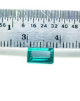 1.16 carat baguette cut loose Colombian emerald from Muzo mine, vivid bluish-green, shown with a ruler.