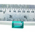 1.16 carat baguette cut loose Colombian emerald from Muzo mine, vivid bluish-green, shown with a ruler.