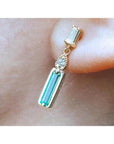 Dangle baguette cut natural emerald stud earrings on a person's ear