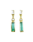 Front position of a baguette cut emerald and diamond pair of earrings in 14k yellow gold, top side view