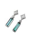 Pair of earrings with baguette cut natural emeralds and diamond tops on a left side profile view