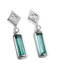 Pair of baguette cut emerald earrings and diamond accents on a top right-side position