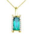 Gold pendant with a emerald baguette cut on a front position topside view.