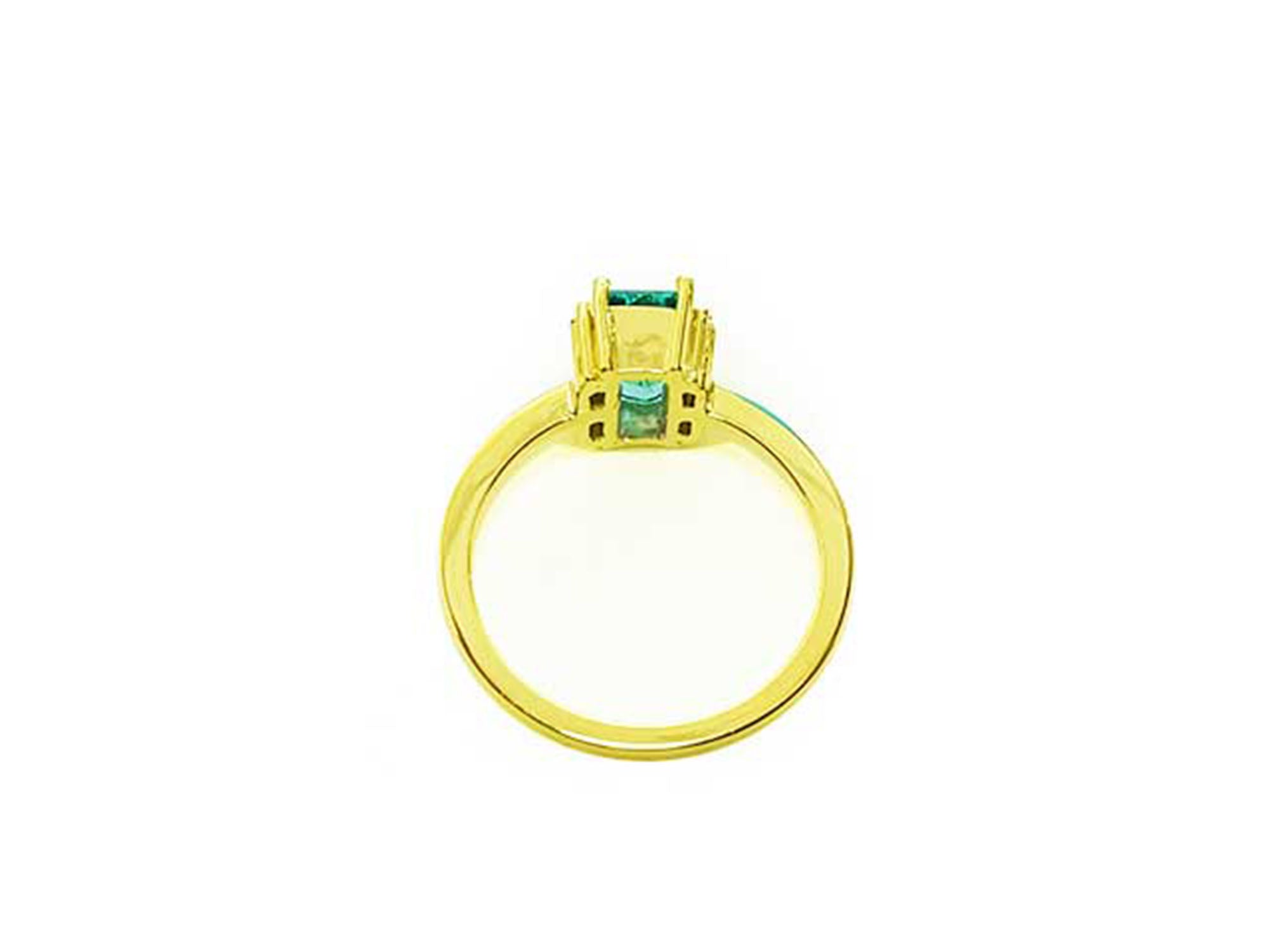 The underside view of a baguette cut emerald and diamond ring.