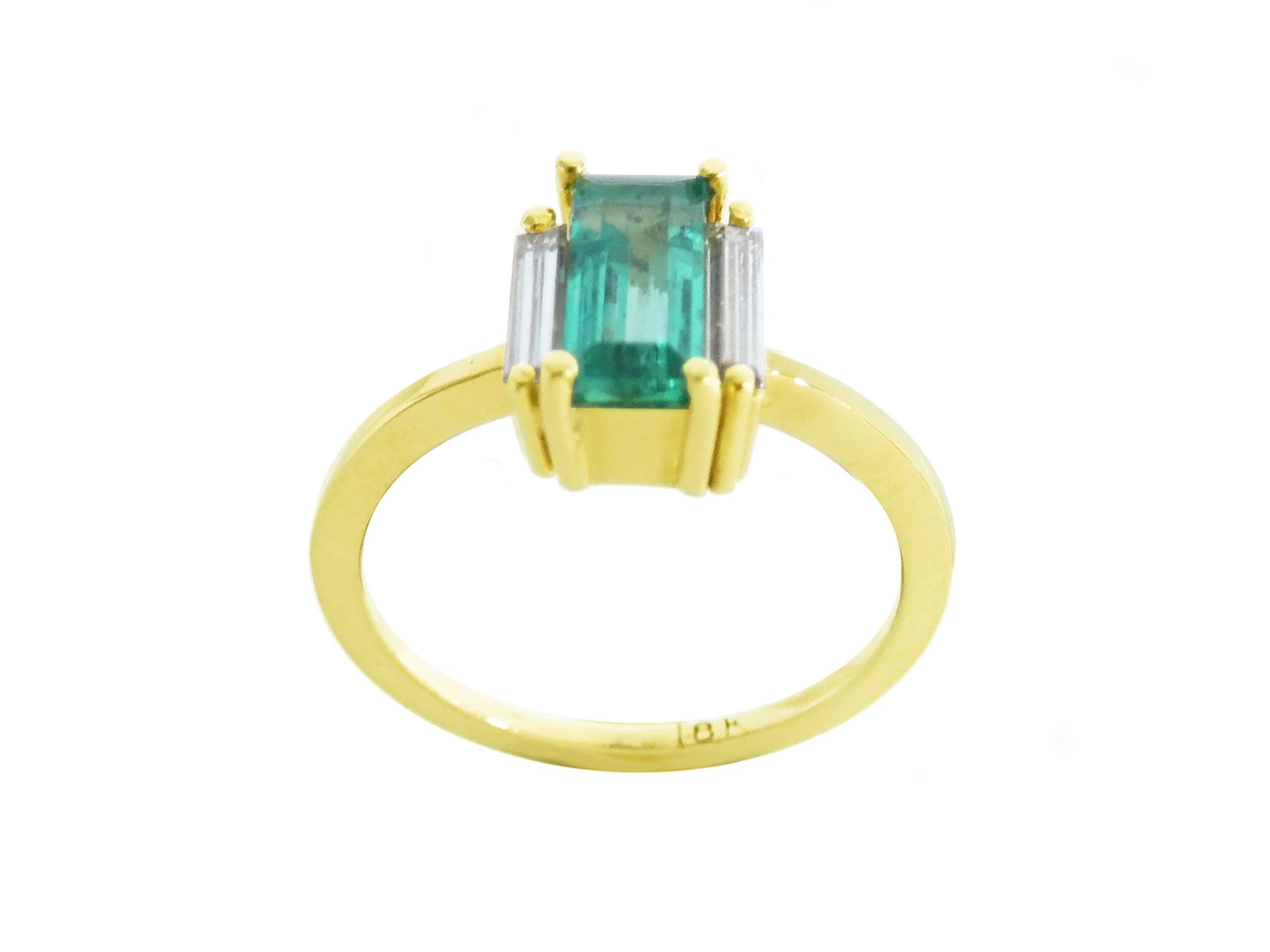 Emerald baguette cut ring 18k yellow gold band on a white background.