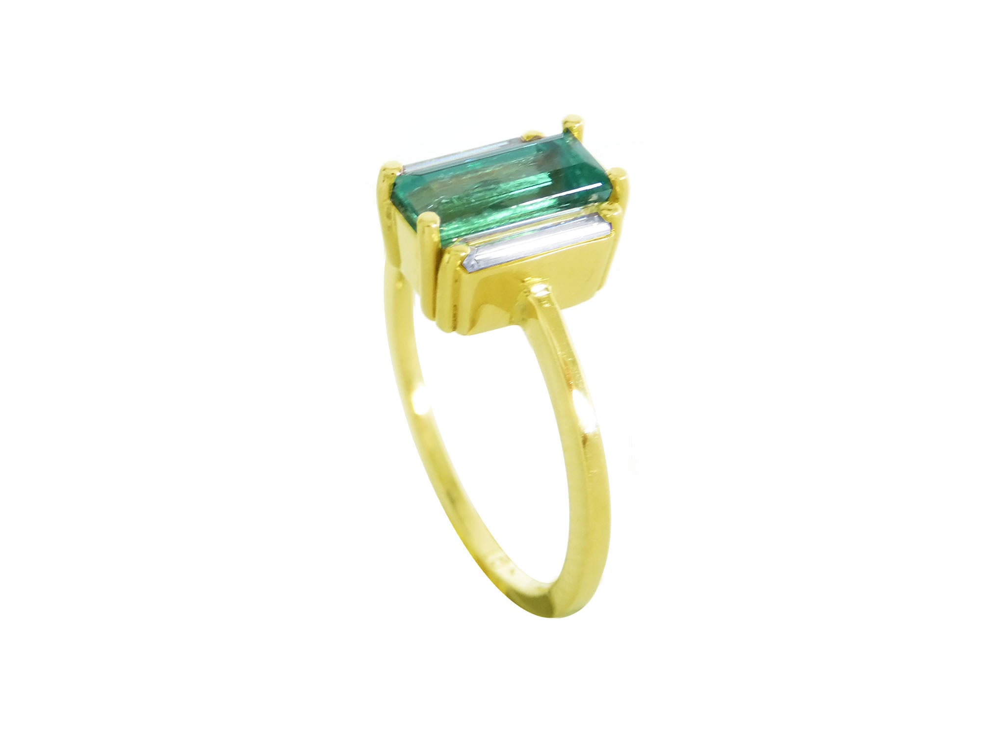 A 18k yellow gold ring with a baguette cut emerald and diamond on a half side profile position.