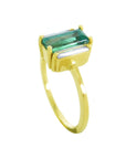 A 18k yellow gold ring with a baguette cut emerald and diamond on a half side profile position.
