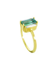 A 18k yellow gold ring with a baguette cut emerald and diamond on a half side profile position.