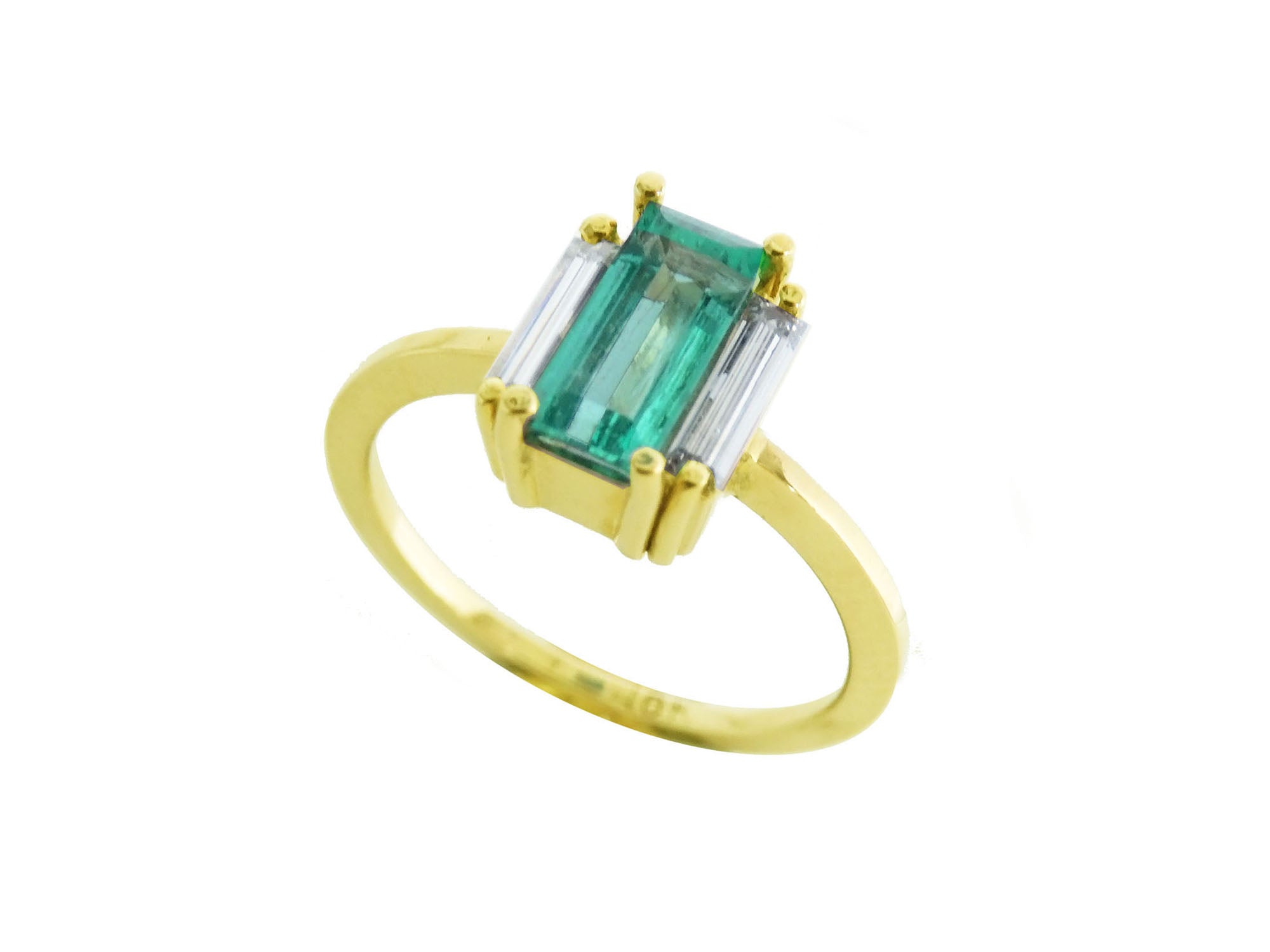 A 18k yellow gold emerald baguette cut ring with side diamonds on a white background.