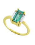 A 18k yellow gold emerald baguette cut ring with side diamonds on a white background.