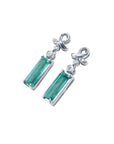 Emerald-cut natural emerald earrings in 14k white gold with ribbon design and accent diamonds.