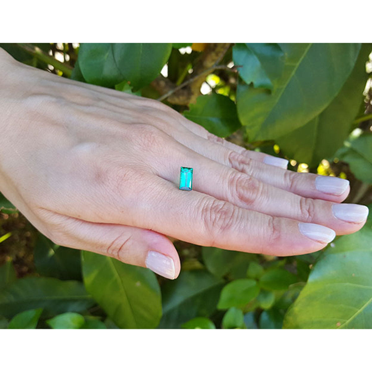 1.62 ct. Fine baguette cut loose natural colombian emerald, front tall position on woman's hand