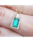 Baguette cut emerald pendant necklace with natural diamonds in 14K yellow gold.