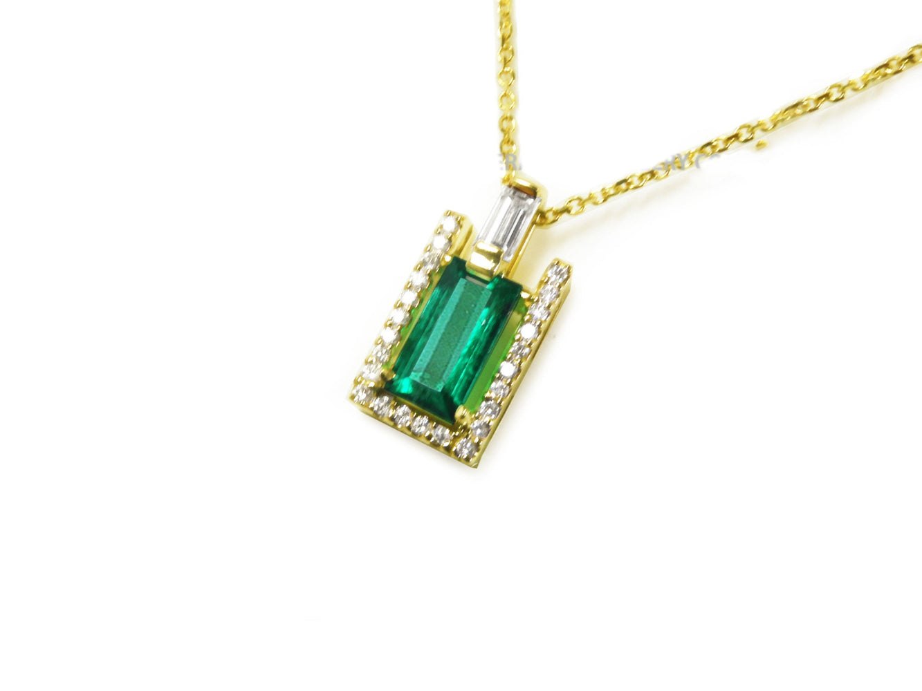 Gold necklace with a natural baguette pendant on a left side position topside view.