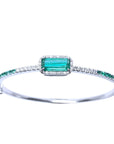 A bangle bracelet with natural colombian emeralds and diamonds crafted in 14l in white gold.
