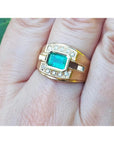 14K yellow gold men's ring with a 1.21 ct. east-west emerald bezel set, surrounded by diamond accents.