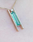 Emerald baguette cut necklace with natural diamonds, 14K yellow gold, and sliding tube bail chain.