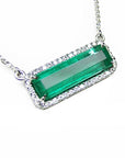 Elongated colombian emerald gemstone necklace encircled in a halo natural diamonds with white gold chain.