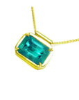 Natural Muzo Colombian emerald solitaire in 18K yellow gold, east-west orientation.